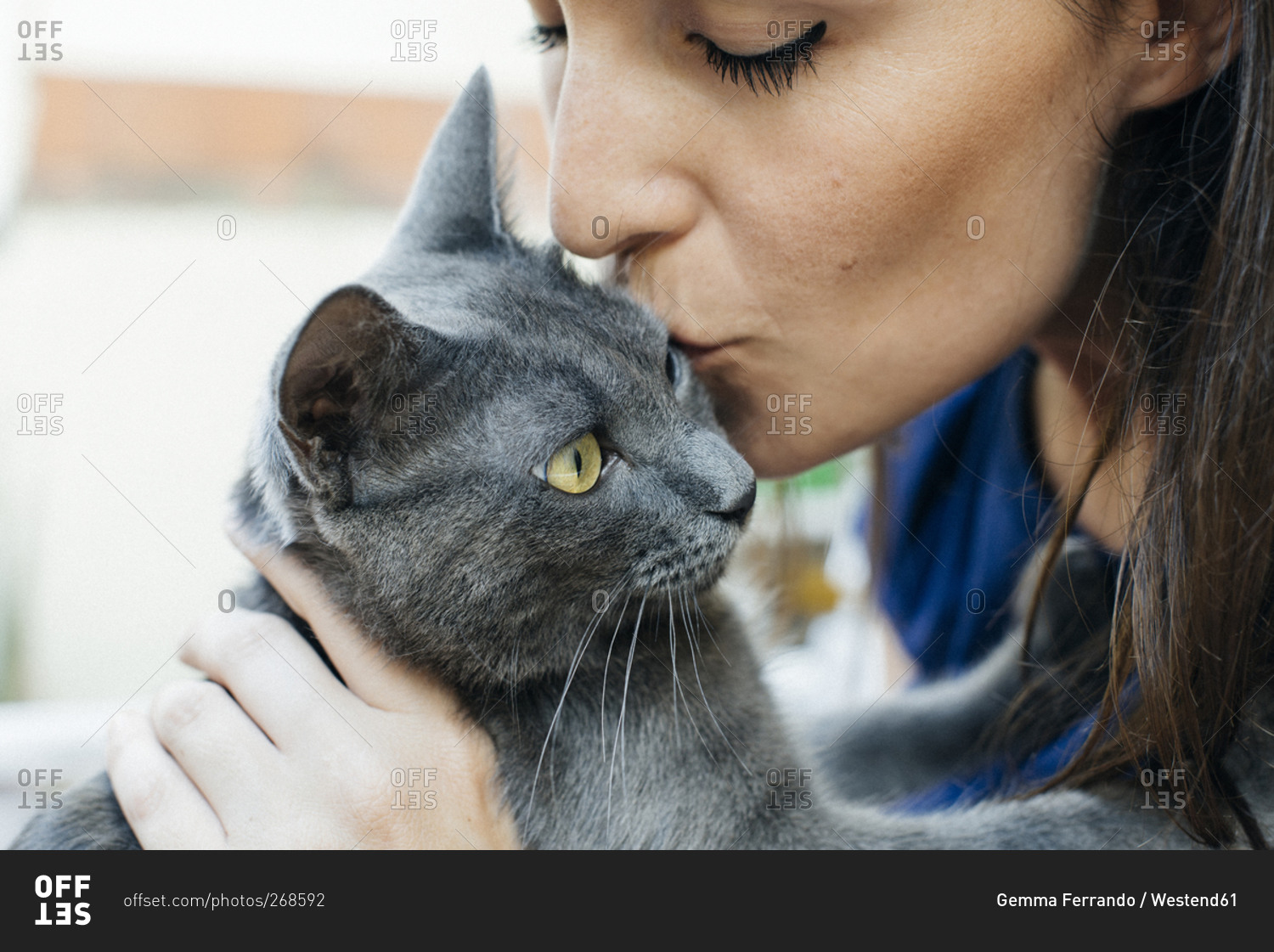 Woman kissing a Russian blue cat