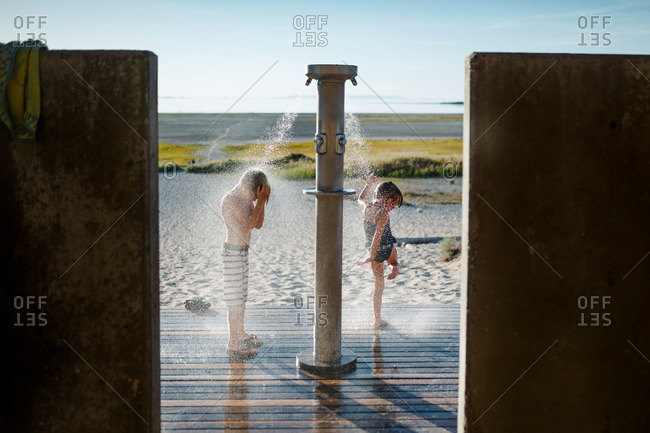 Two Young Children Rinsing Off In Outdoor Shower Stock Photo OFFSET