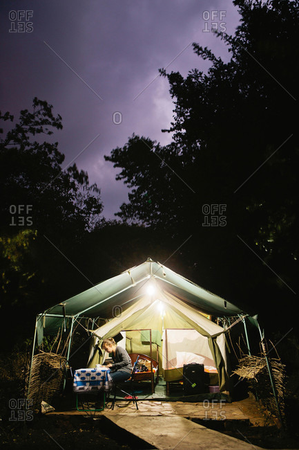A woman at dusk in a safari tent in the Maasai Mara, Kenya