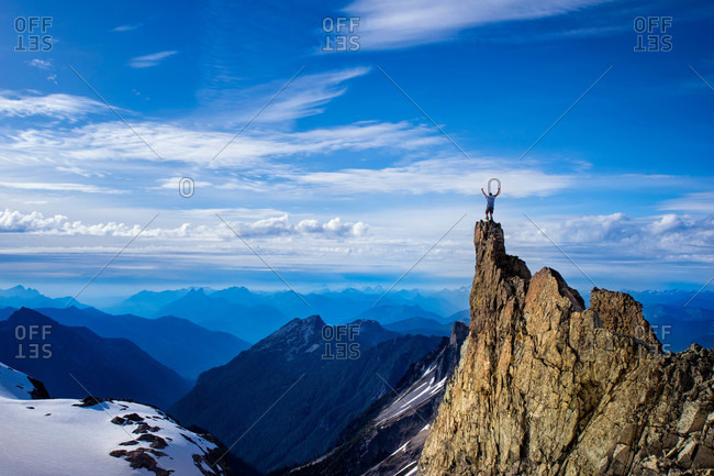 Man stands on a rocky point above the Lynch Glacier Clouds