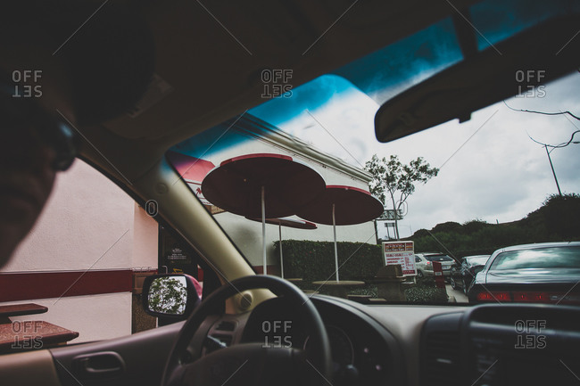 Man driving a car in a fast food restaurant drive-thru