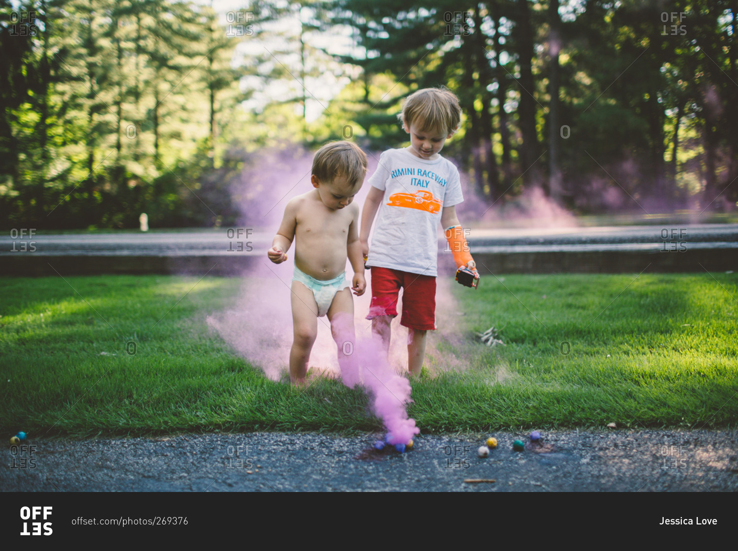 Little boys playing with colored smoke bombs