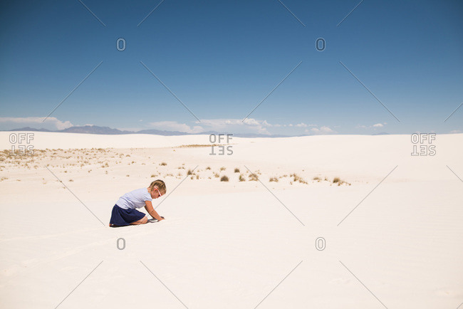 Little girl playing in white sand, White Sands National Monument in Alamogordo, New Mexico