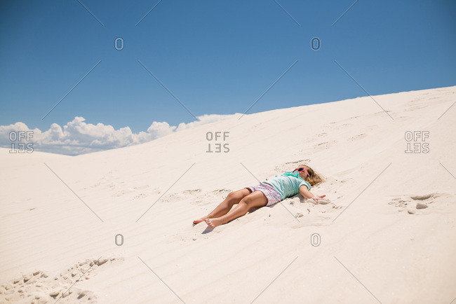 Little girl lying on a white sand dune, White Sands National Monument in Alamogordo, New Mexico