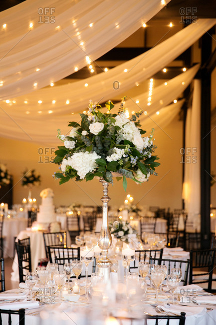 Tall Vase With Flower Arrangement On Table At Wedding Reception