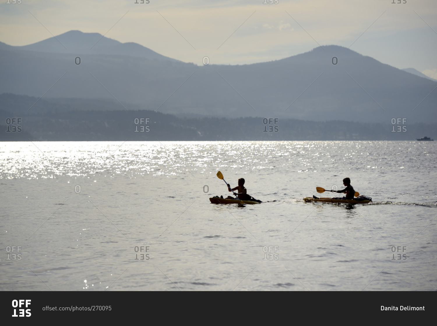 Two kids kayaking in front of Vancouver Island