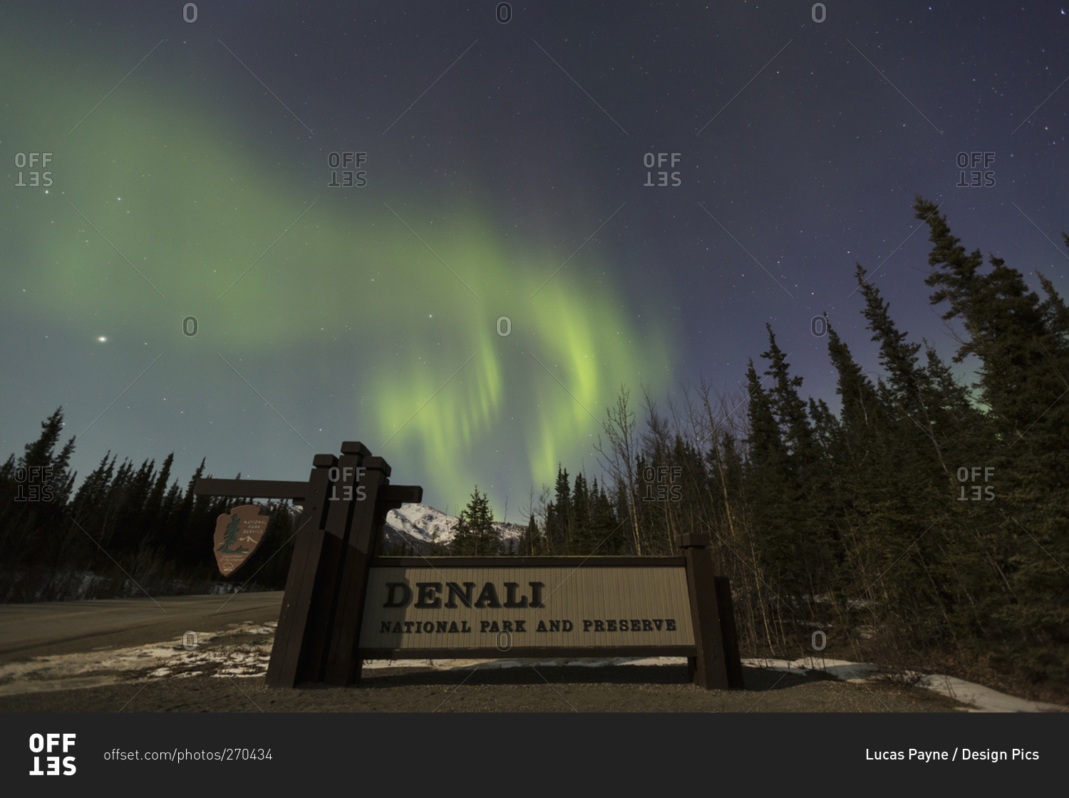 The Aurora Borealis (Northern Lights) dancing above the sign marking the entrance to Denali National Park and Preserve, Alaska, United States of America