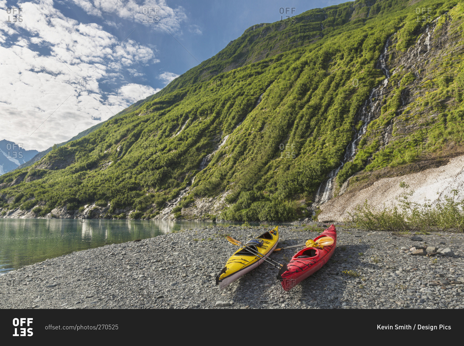 Two kayaks on the beach in front of green mountain with waterfall at Shoup Bay State Marine Park, Prince William Sound, Valdez, Alaska, United States of America