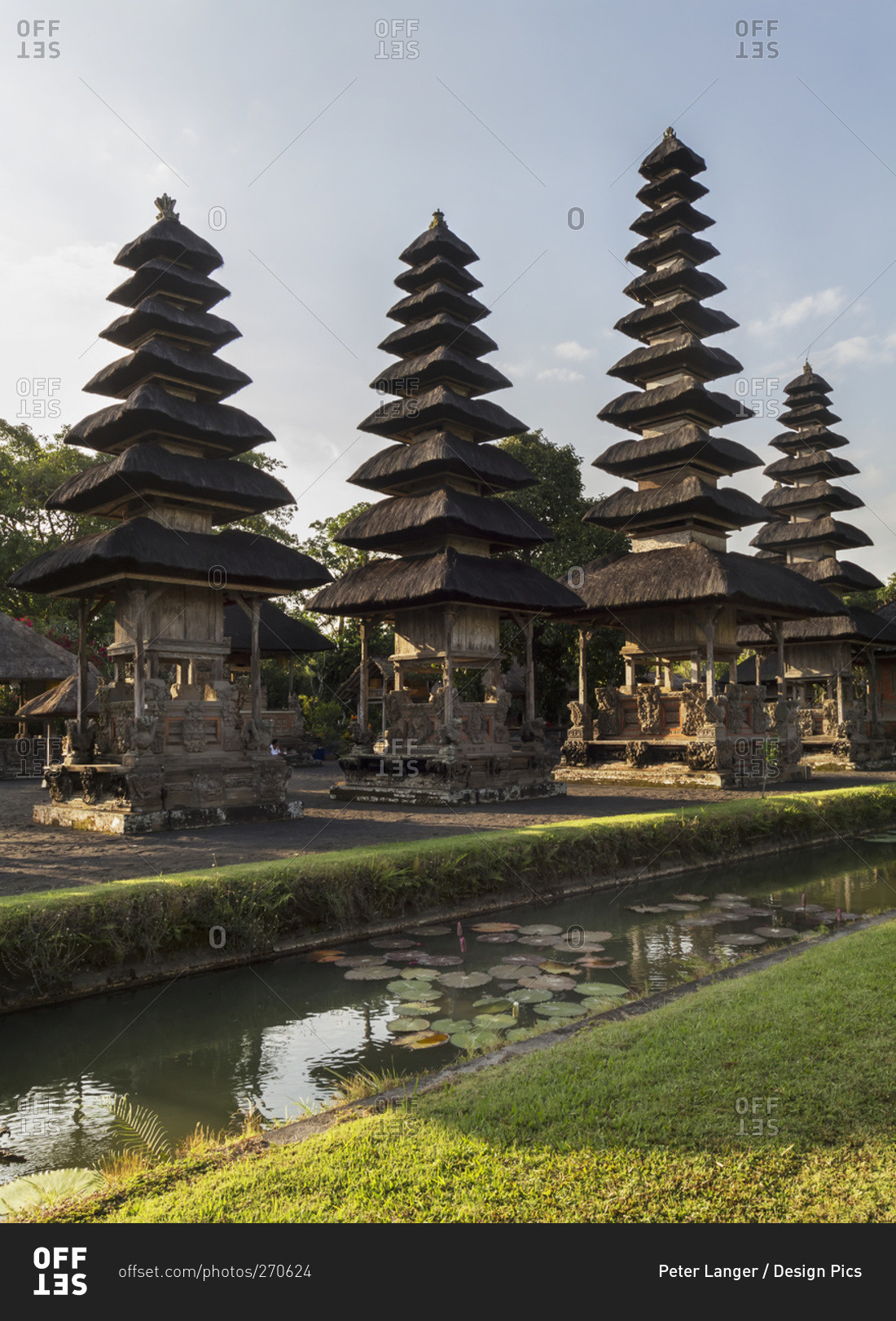 Moat surrounding classical tiered thatched-roofs merus (towers) in the Royal Water Temple Pura Taman Ayun, Mengwi, Bali, Indonesia