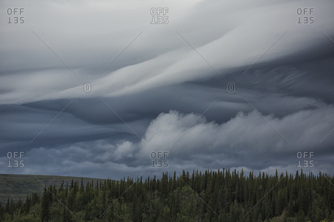 Lenticular clouds form over the flanks of Crow Mountain, Old Crow, Yukon, Canada