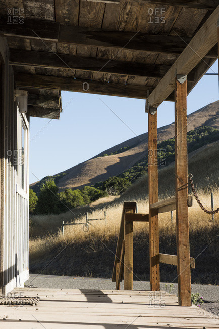 Covered porch of a rustic building in a hilly landscape