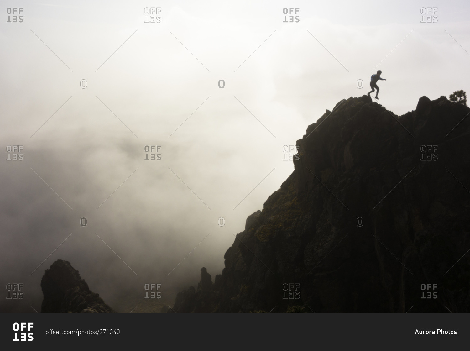 Man silhouetted by clouds while hiking