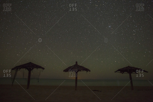 Nighttime image of palapas with stars