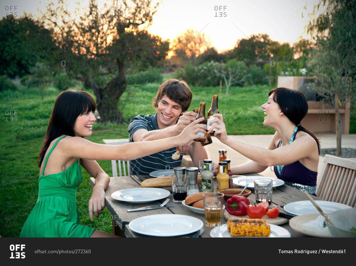 Me And My Friends At The Table Doing Shots Happy friends sitting at garden table on a barbecue clinking beer