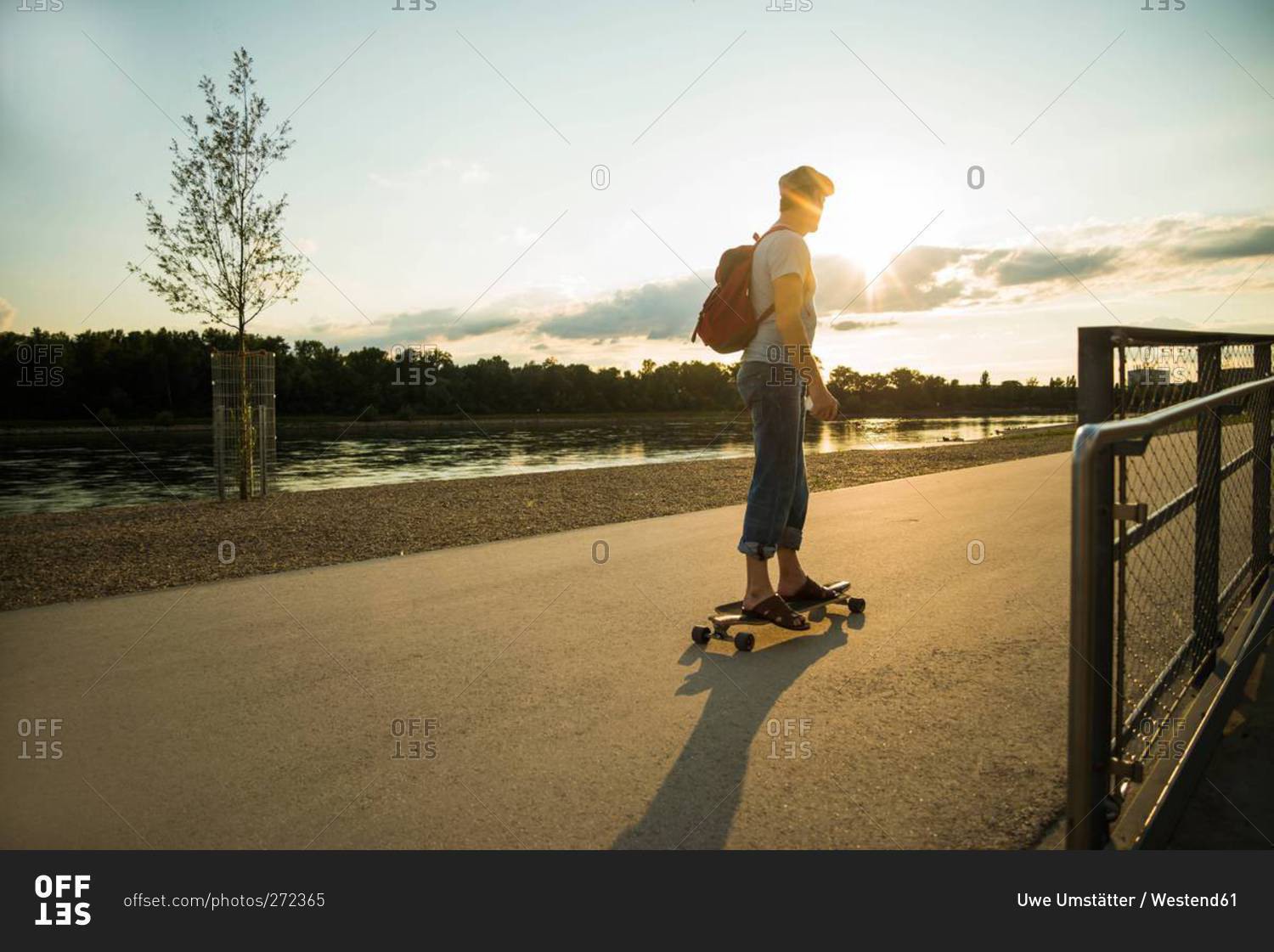 Man standing on skateboard in the evening twilight