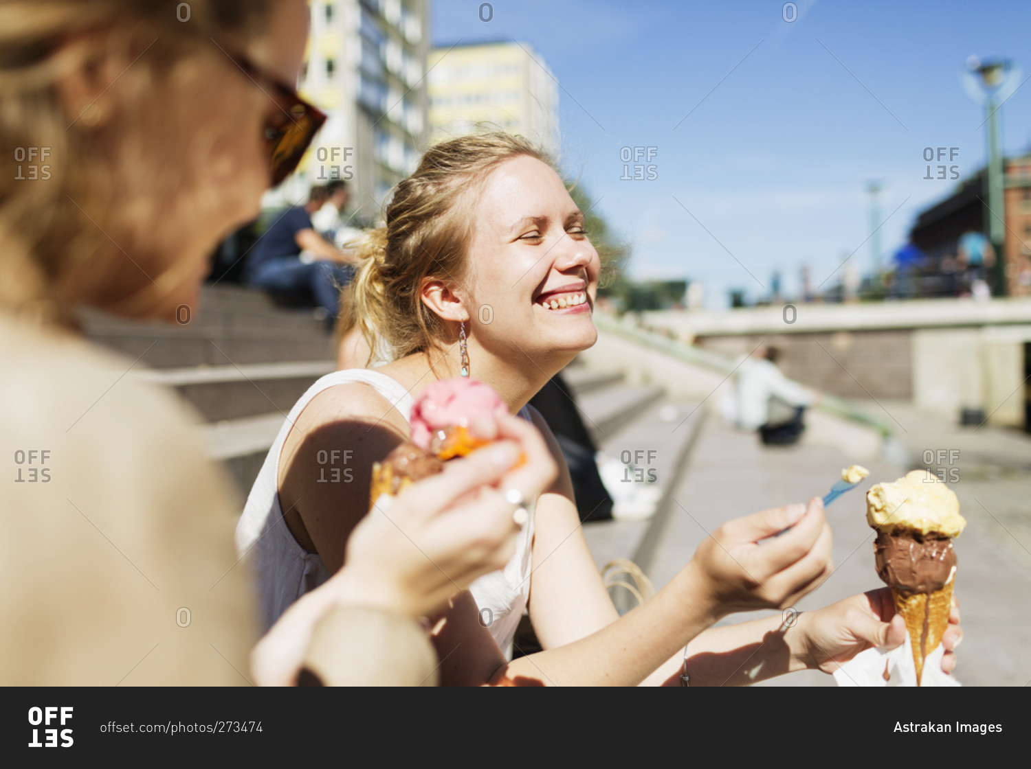 Two women sitting on outdoor steps enjoying ice cream cones stock photo ...