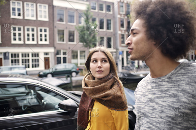Couple having a conversation while walking together on Amsterdam street