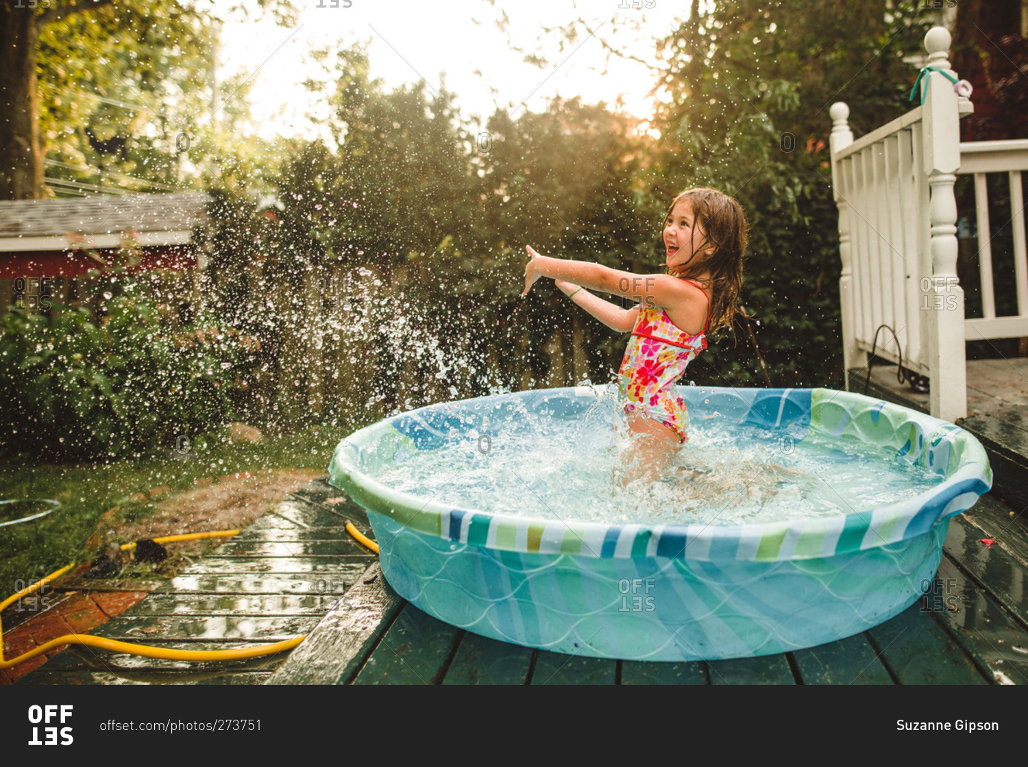 Girl splashing water in a kiddie pool