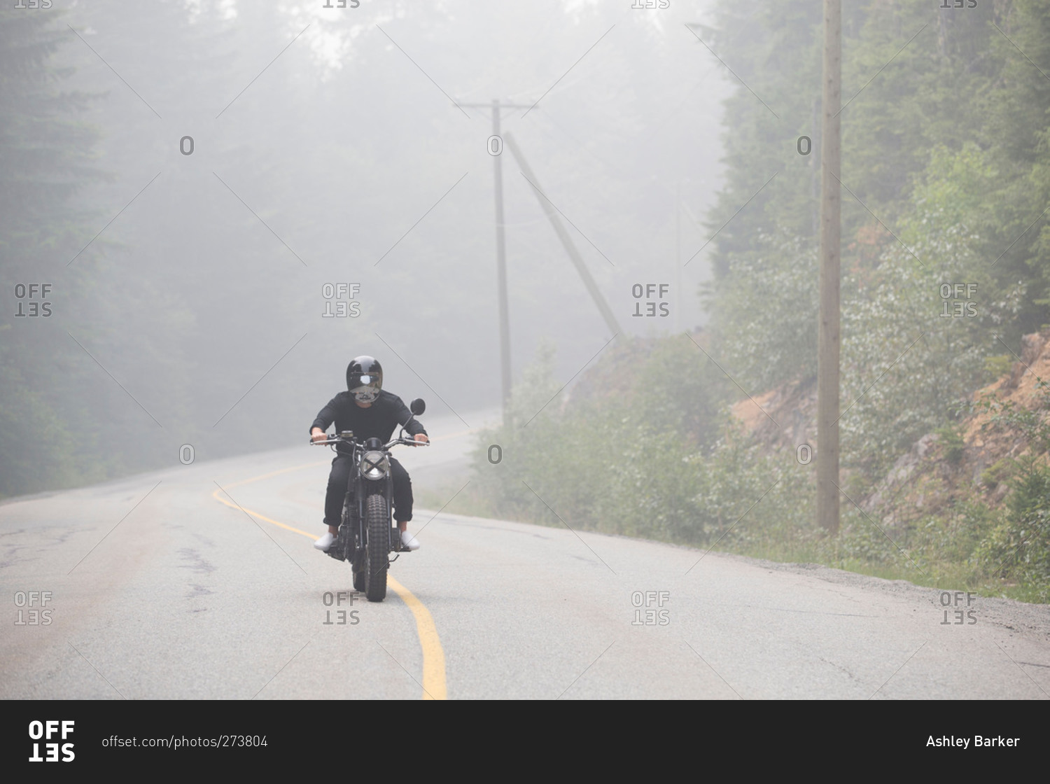 Man on motorcycle on misty rural highway
