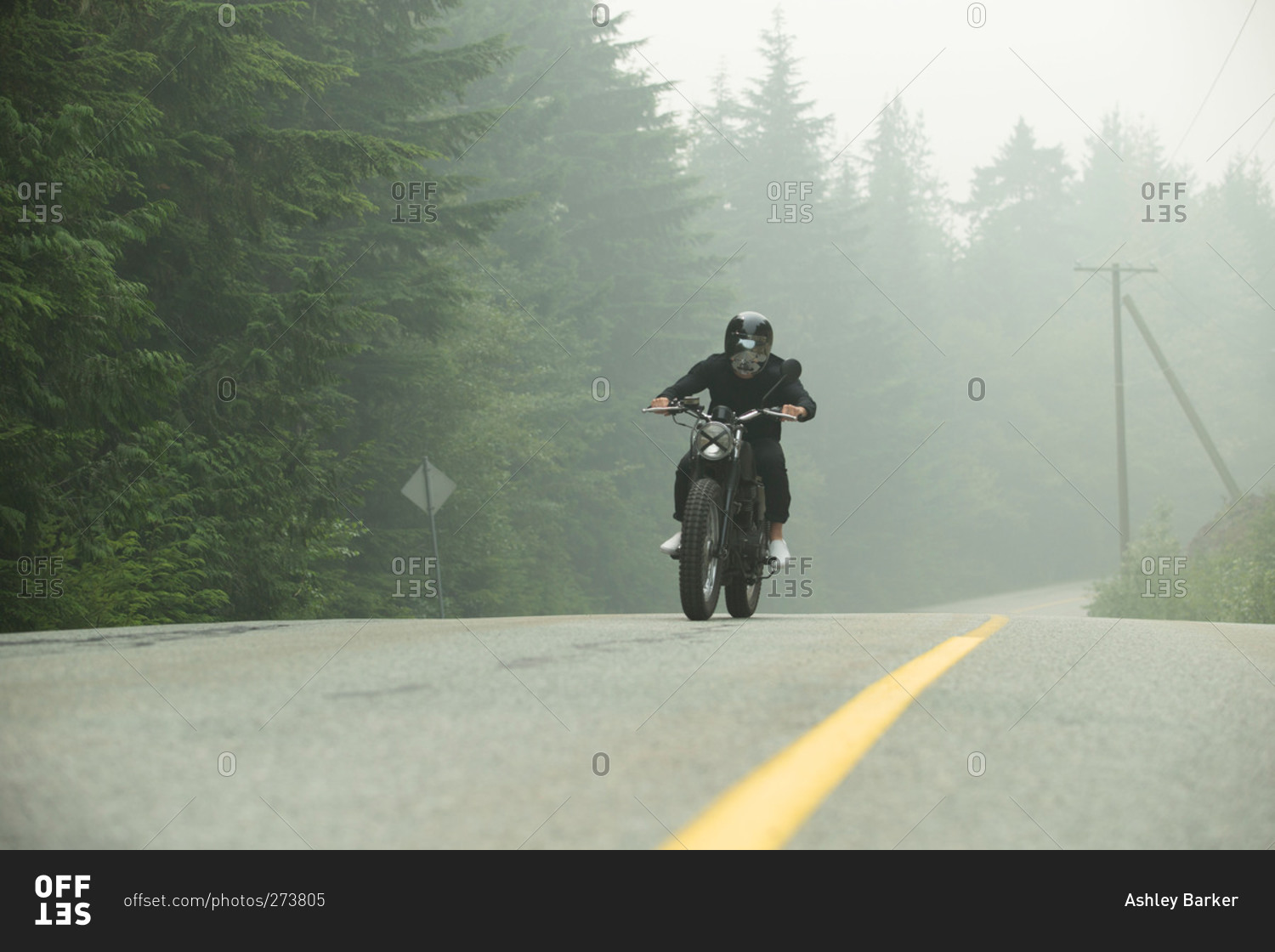 Man on motorcycle on misty rural road