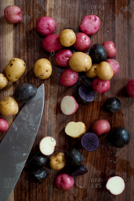 Multiple colored potatoes on a cutting board