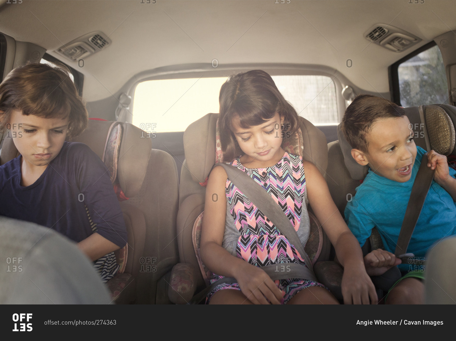 Children in child seats riding in a car
