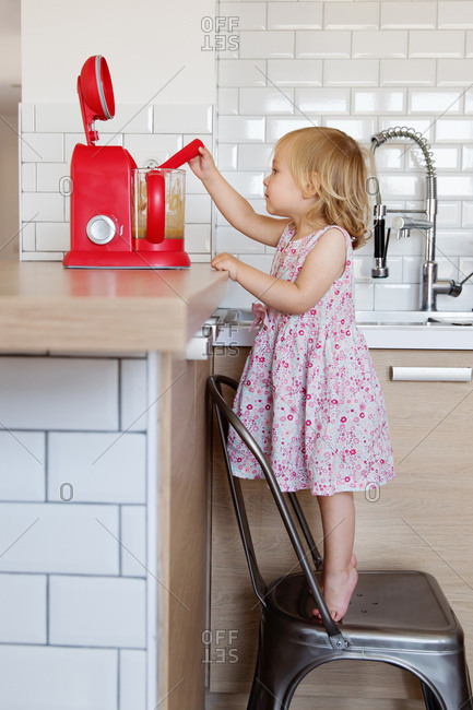 Little girl stirring homemade applesauce in a blender