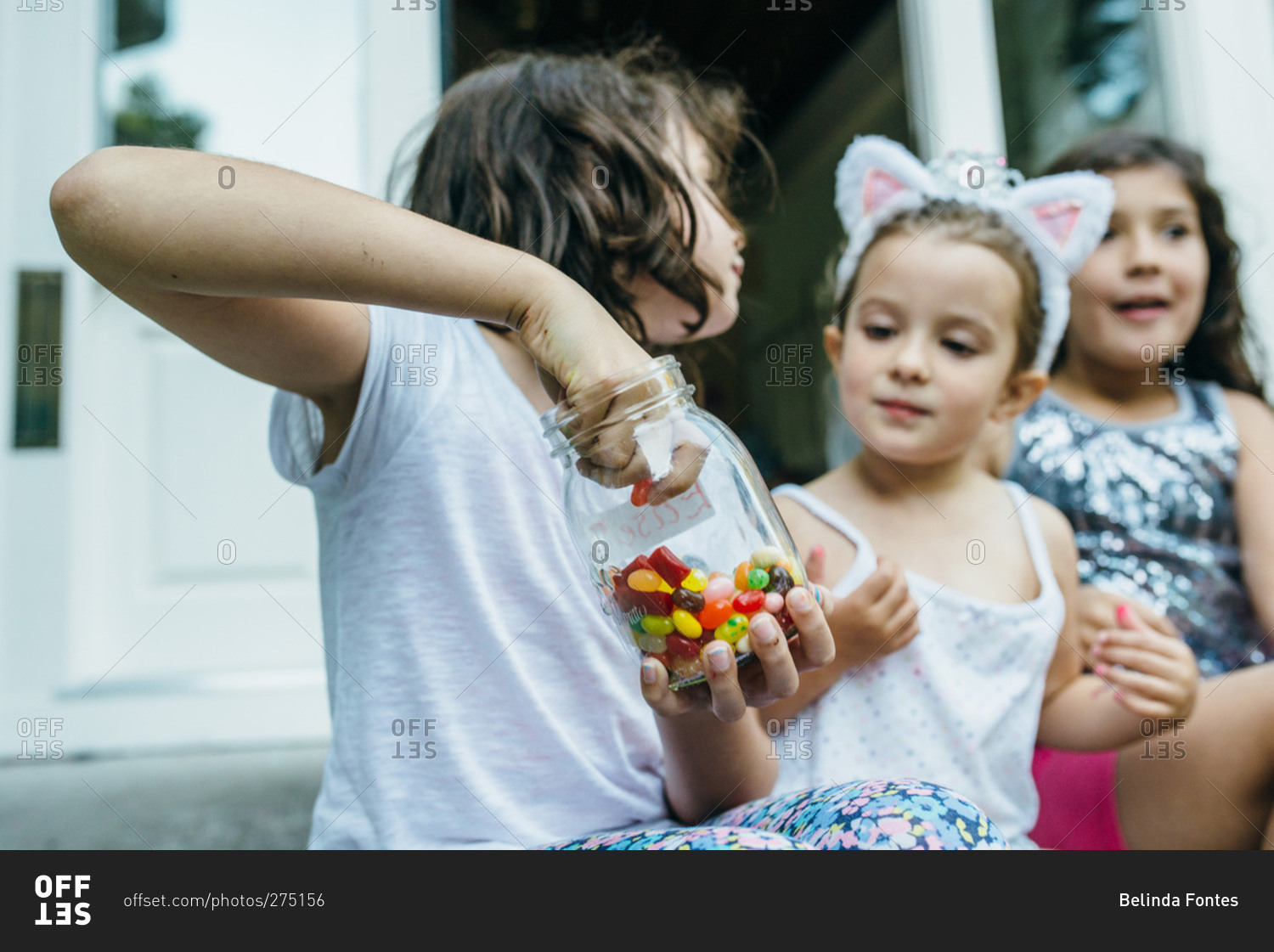 Girls sharing a jar of jelly beans