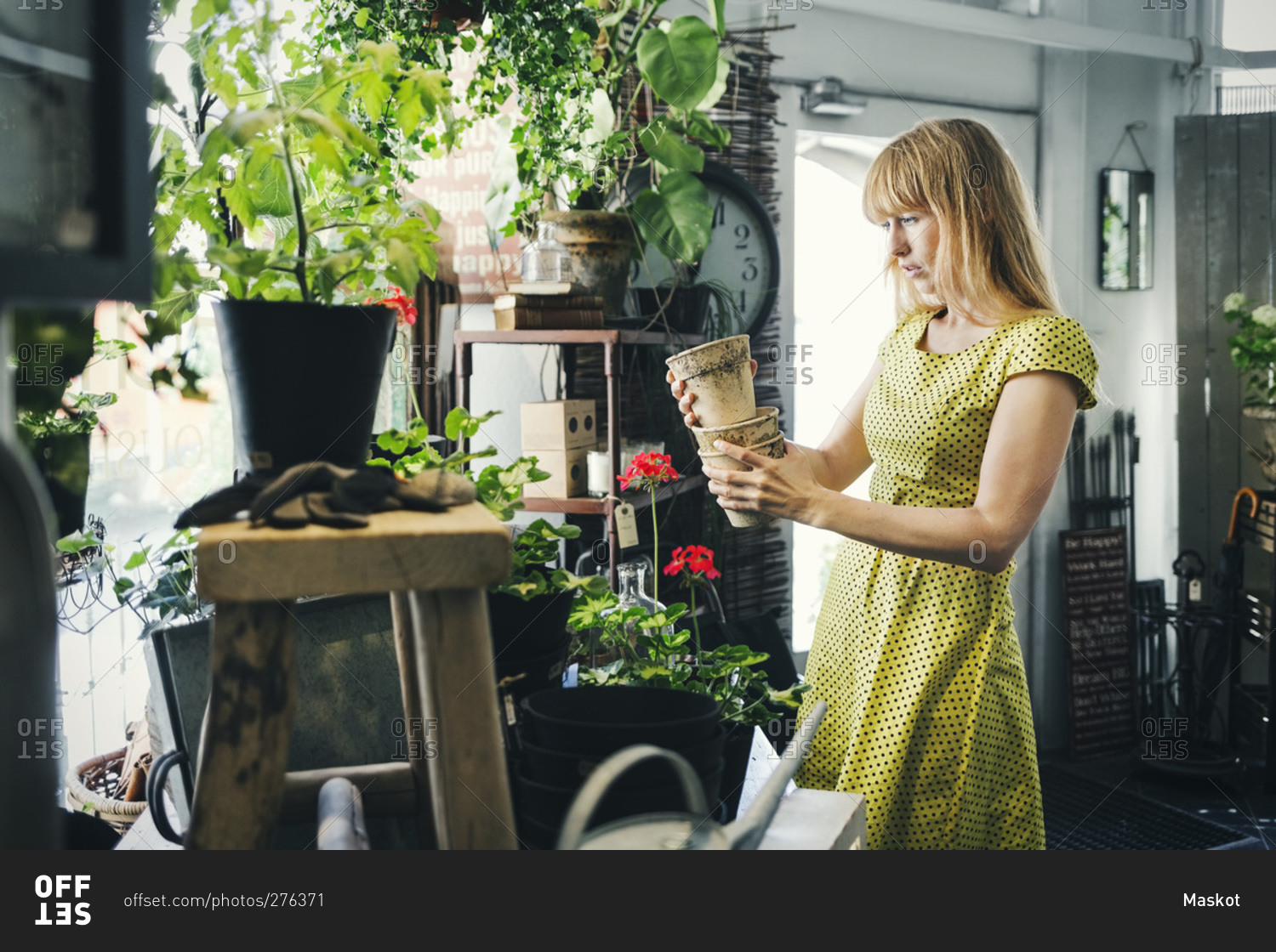 Mid adult woman holding pots in an interior design shop
