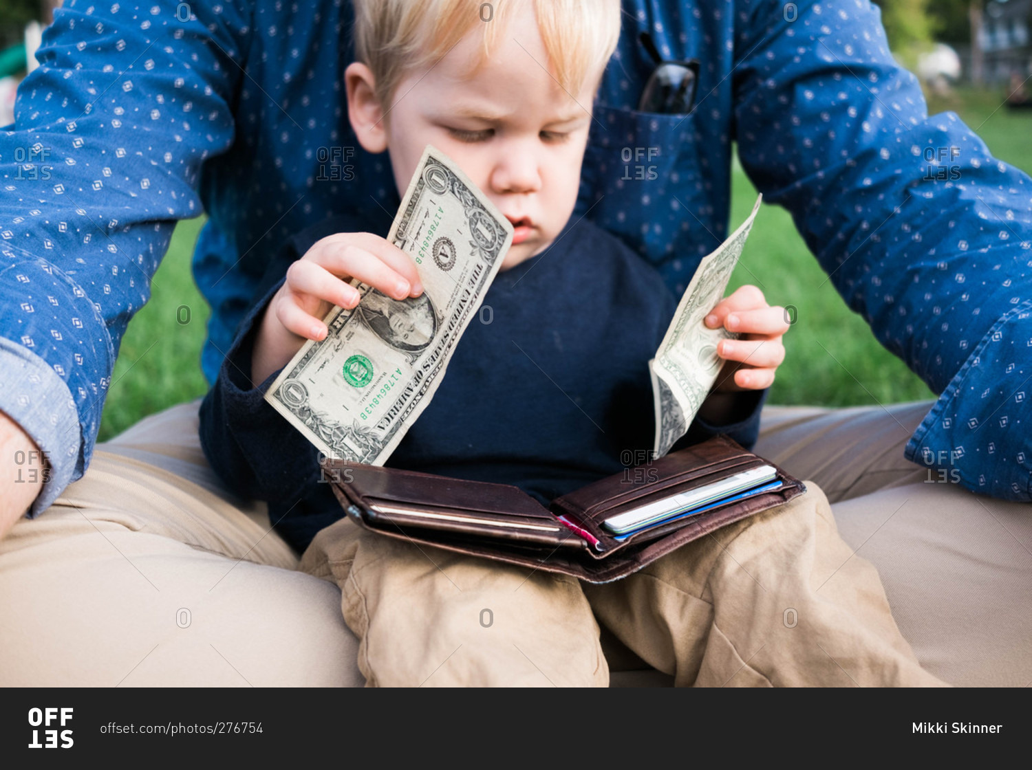 Little boy looking at money and a wallet