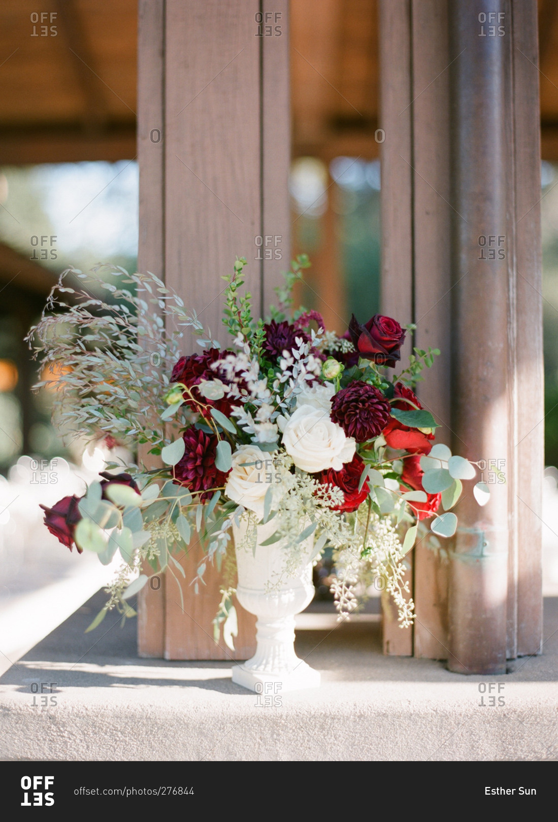 Wedding flower arrangement of white roses and dark red roses and dahlias