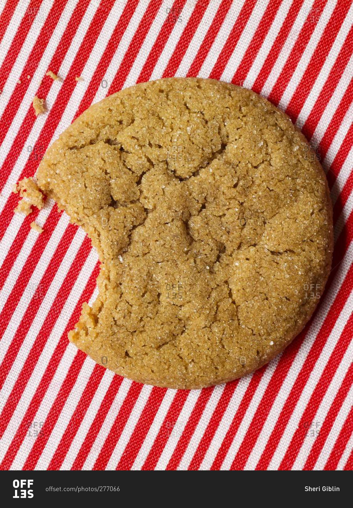 Bitten ginger cookie on a red and white striped background