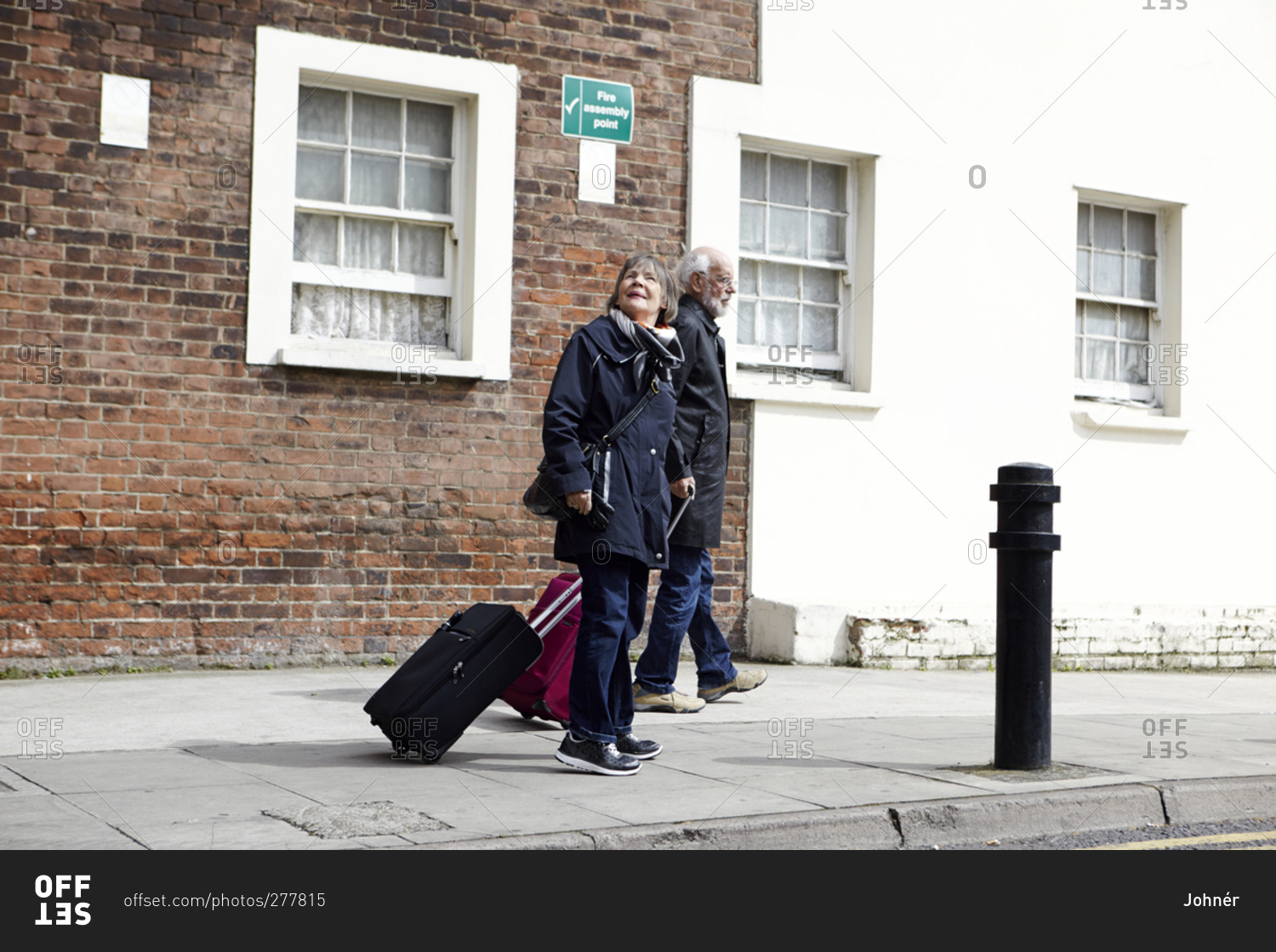 Senior couple walking with luggage