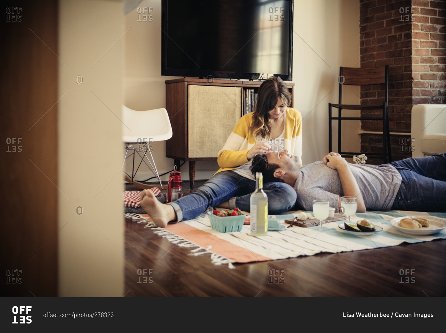 Couple having a picnic on their living room floor