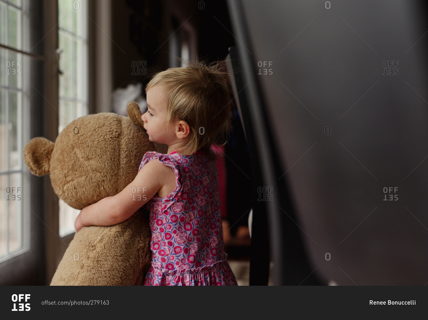 girl hugging huge teddy bear