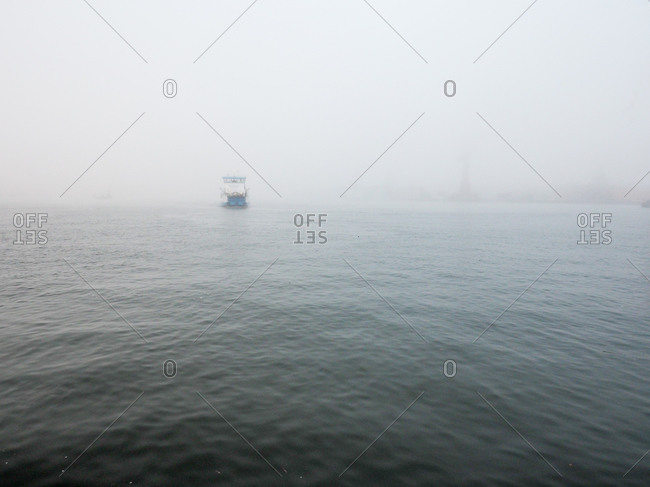Distant boat across foggy waters in Gothenburg, Sweden