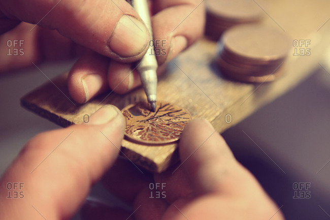 Craftsman designing a metal coin