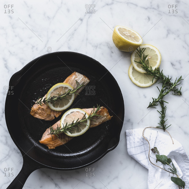 Salmon filets with lemon and rosemary in pan
