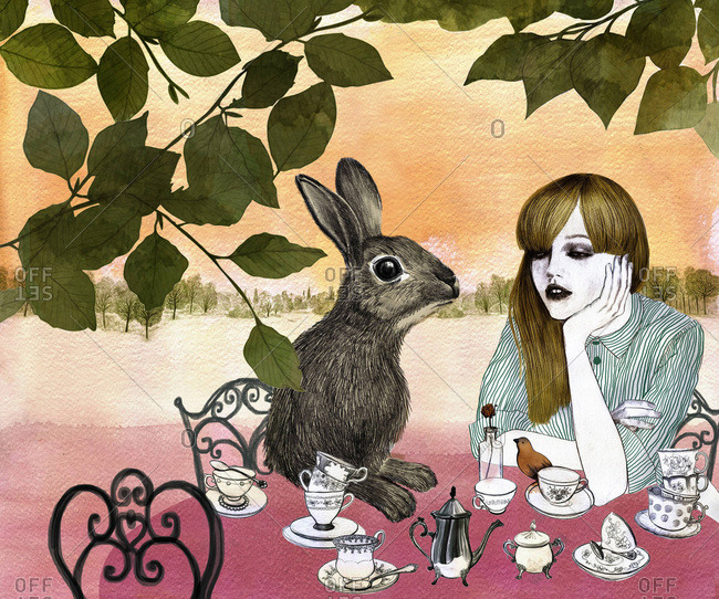Young woman having tea with a rabbit