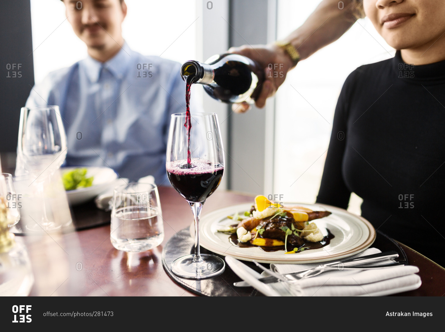 Server pouring wine at a restaurant