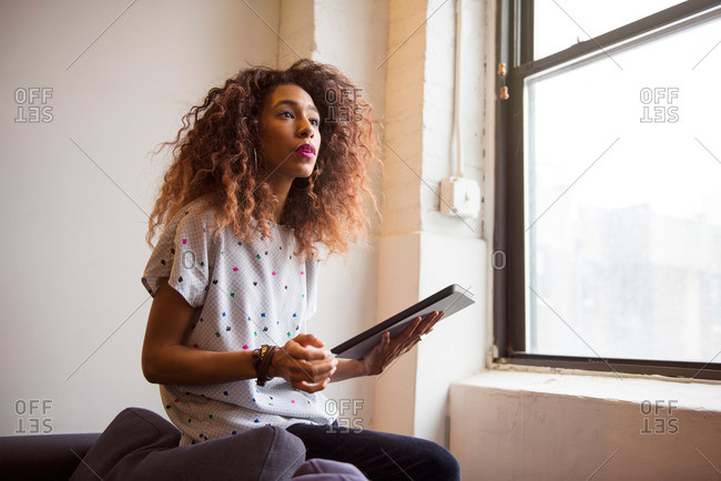 African American woman in loft with a tablet