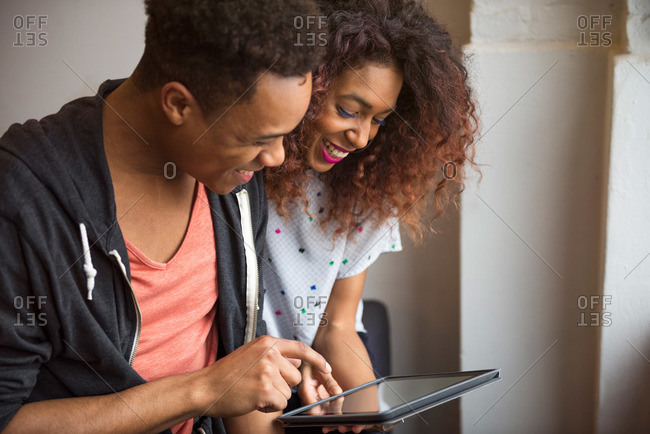 African American man and woman in loft with tablet