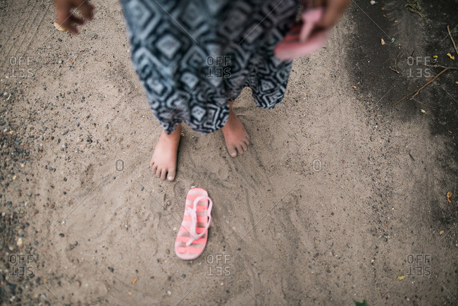 Dirty feet of a little girl in sand stock photo - OFFSET