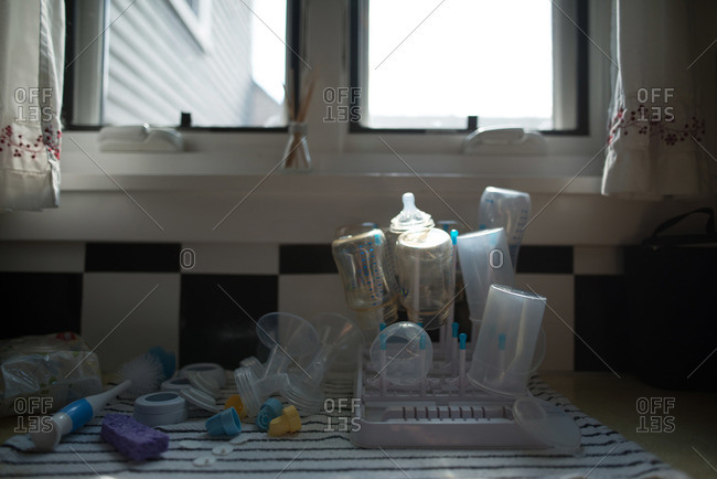 Baby bottles drying on a rack on a kitchen counter