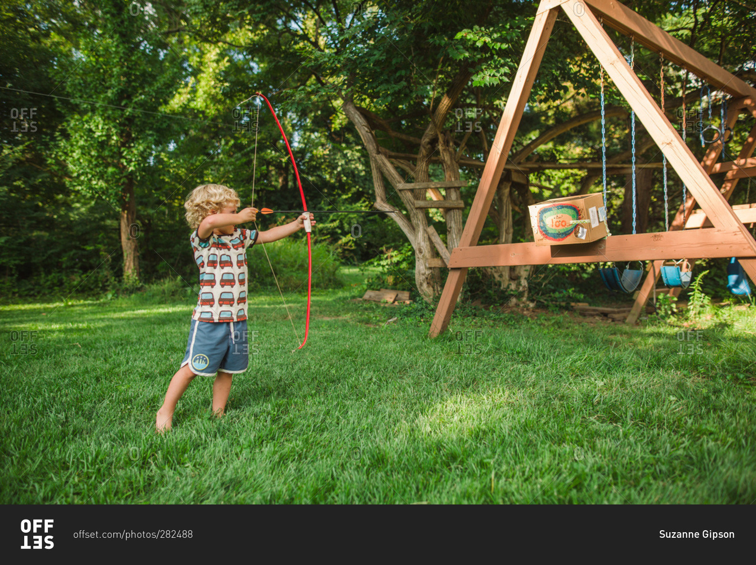 Little boy using a bow and arrow stock photo OFFSET