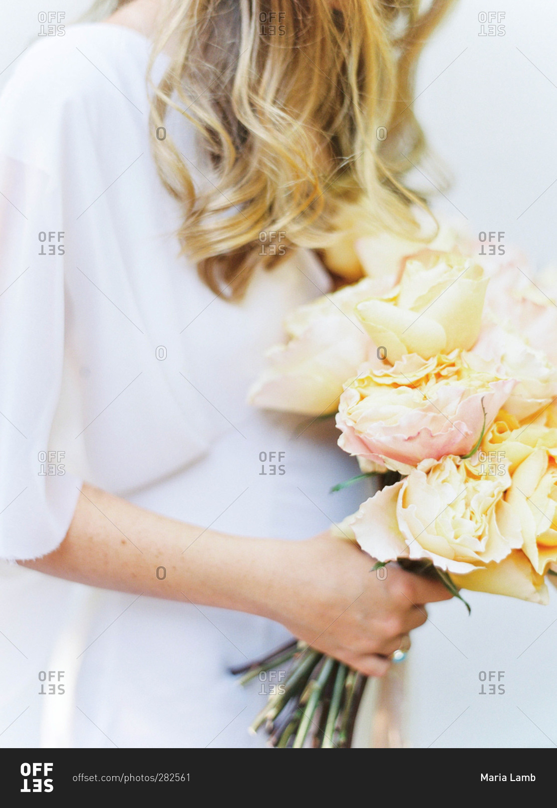 Bride holding bouquet of yellow roses