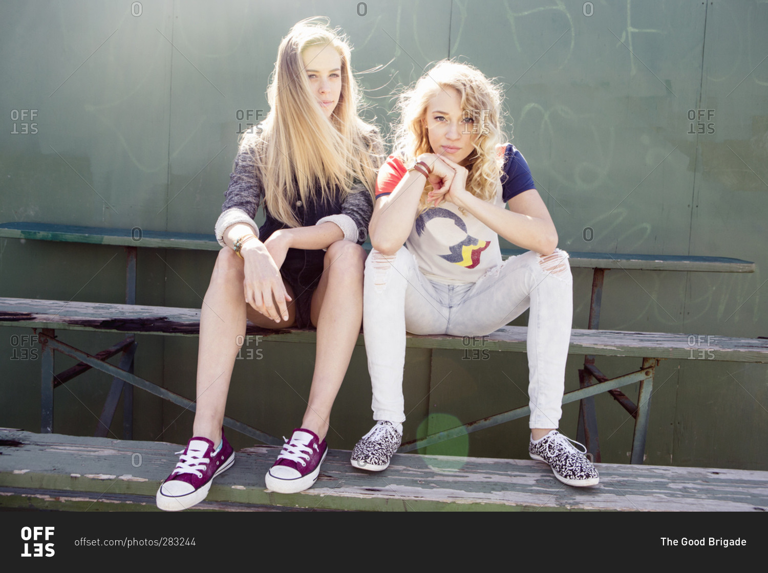 Portrait of two teen girls sitting on bleachers stock photo OFFSET