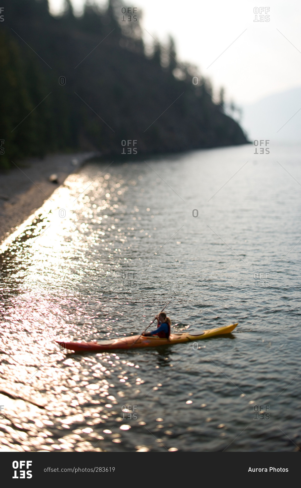 Woman kayaking to shore on an Idaho Lake in late summer