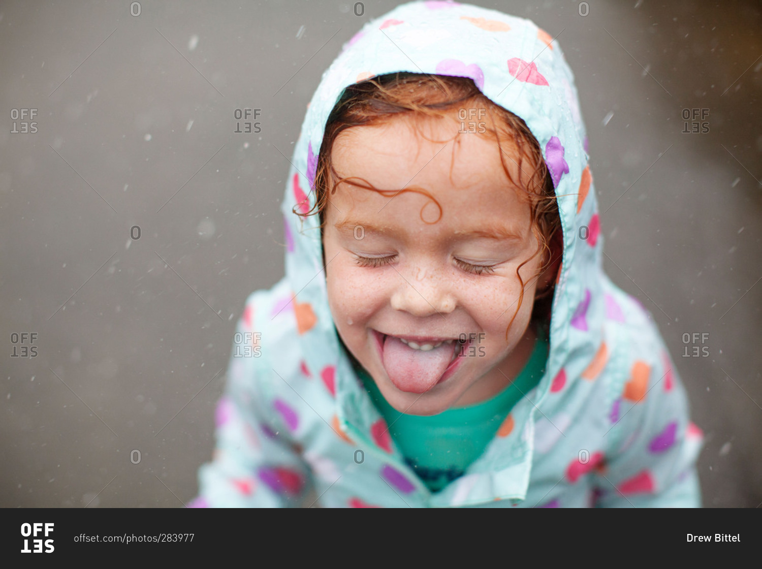 Girl sticking tongue out in pouring rain