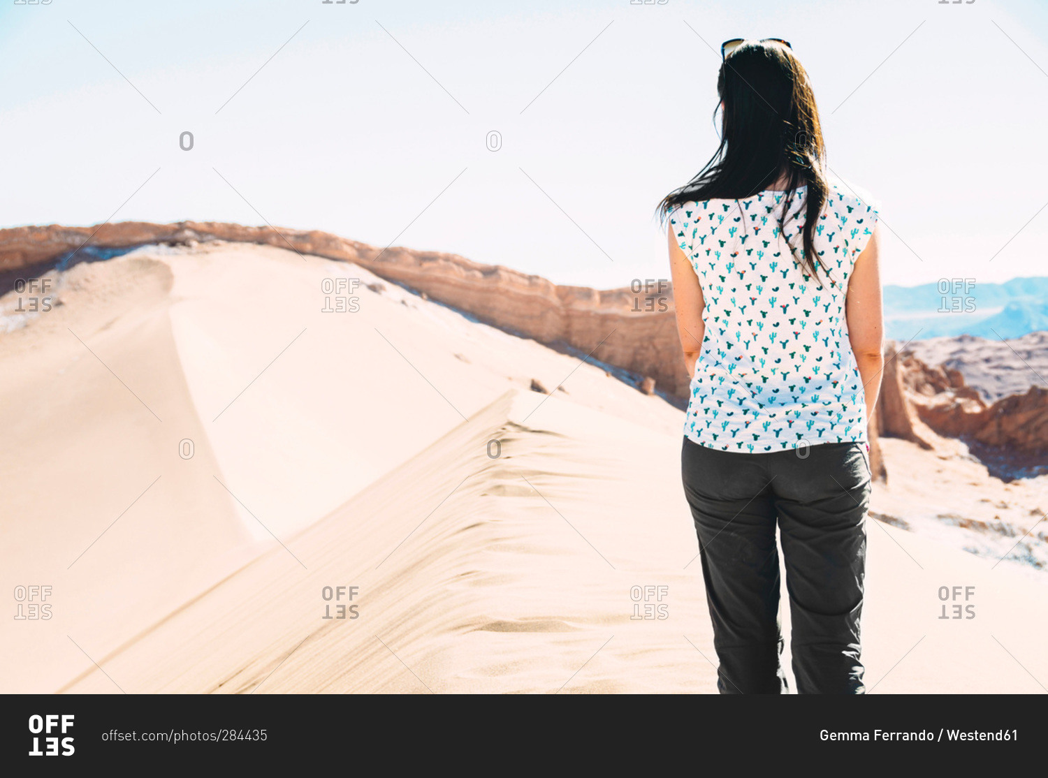 Woman standing on big dune looking at view, Atacama Desert